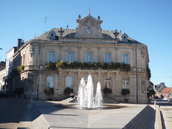 Vue aérienne ou photo panoramique de la ville de Caudry dans le Nord de la France, montrant le paysage urbain et rural caractéristique de la région, avec maisons individuelles et toitures visibles. L'image doit être prise en conditions lumineuses naturelles professionnelles, sans texte ni logo.